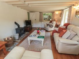 A living room with a wood stove and sofa at Quoits Cottage in Beck Hole near Goathland