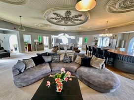A living room with a large sofa and a bar counter at Capel Mawr in Llanrug near Llanberis