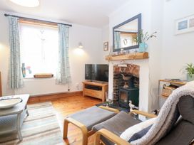 A living room with a television and fireplace at Driftwood Cottage Heacham