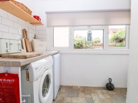 A laundry room with appliances and windows at Driftwood Cottage Heacham