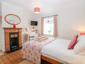 A bedroom with a bed and desk at Driftwood Cottage in Heacham