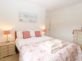 A bedroom with a bed and bedside lamps at Driftwood Cottage in Heacham