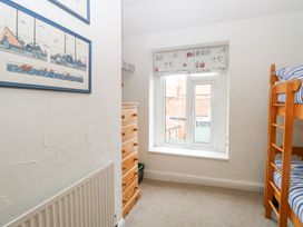 A bedroom with a bunk bed and a window at Driftwood Cottage in Heacham