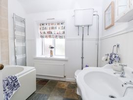 A bathroom with a bathtub, toilet, and sink at Driftwood Cottage in Heacham