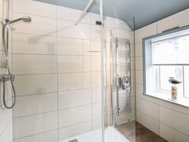 A bathroom with a shower and towel rail at Driftwood Cottage in Heacham