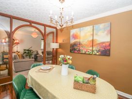 A dining room with a table and green chairs at Kempton in Bowness-on-Windermere
