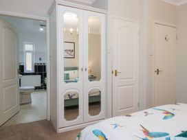 A bedroom with a wardrobe and bathroom access at Kempton in Bowness-on-Windermere