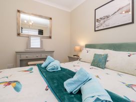 A bedroom with a bed and mirror at Kempton in Bowness-on-Windermere