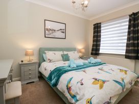 A bedroom featuring a bed with colorful bedding at Kempton Bowness-on-Windermere