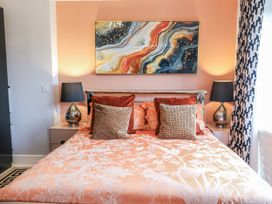 A bedroom featuring a bed with cushions and bedside lamps at Smithy Cottage in Cemaes Bay