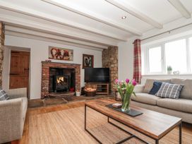 A living room with a fireplace and sofa at Wold Cottage in Hunmanby