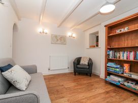 A sitting room with a sofa and bookshelf at Wold Cottage in Hunmanby