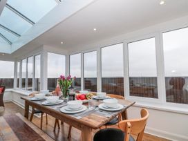 A dining table set with dishes and flowers at Wold Cottage in Hunmanby
