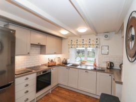A kitchen equipped with appliances and a window at Wold Cottage in Hunmanby