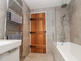 A bathroom with a towel radiator and a wooden door at Wold Cottage in Hunmanby