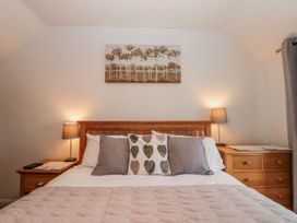 A bedroom with a bed and decorative pillows at Wold Cottage in Hunmanby
