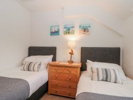 A bedroom with two single beds and a nightstand at Wold Cottage in Hunmanby