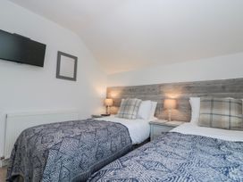 A bedroom with two twin beds and a television at Wold Cottage in Hunmanby