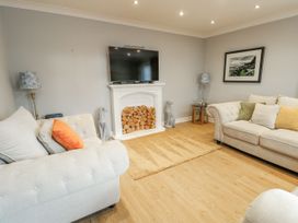 A living room with a television and a rug at 1 The Old Smithy in Cemaes Bay