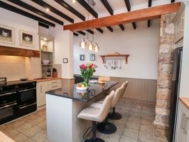 A kitchen with an island and stools at The Farmhouse in Boggle Hole near Robin Hood's Bay