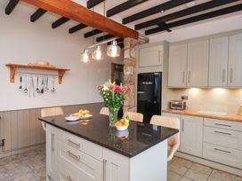 A kitchen with an island and flowers at The Farmhouse in Boggle Hole near Robin Hood's Bay