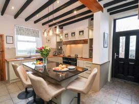 A kitchen with an island and seating at The Farmhouse in Boggle Hole near Robin Hood's Bay