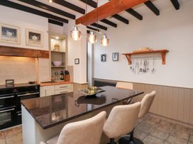 A kitchen with a black oven and island with bar stools at The Farmhouse in Boggle Hole near Robin Hood's Bay