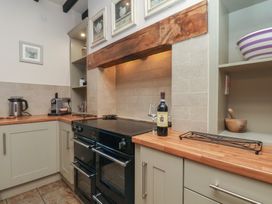 A kitchen with a cooking range and wine bottle at The Farmhouse in Boggle Hole near Robin Hood's Bay