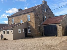 A house with a garage and gravel driveway at The Farmhouse in Boggle Hole near Robin Hood's Bay
