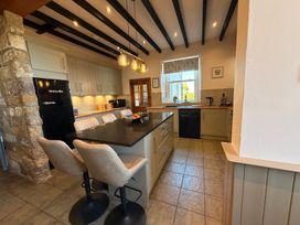 A kitchen with an island and black refrigerator at The Farmhouse in Boggle Hole near Robin Hood's Bay