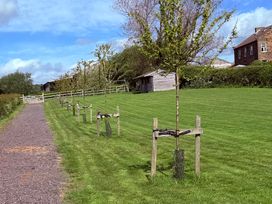 A pathway alongside trees and a building at The Farmhouse in Boggle Hole near Robin Hood's Bay