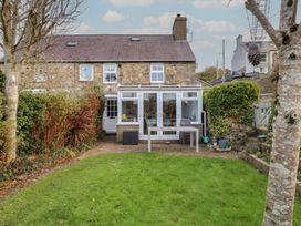A garden with a house and outdoor furniture at Dolfor in Nefyn