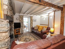 A living room with a tv and sofa at Dolfor in Nefyn