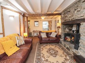 A living room with a fireplace and sofas at Dolfor in Nefyn