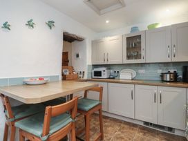 A kitchen with cabinets and a table at Dolfor in Nefyn