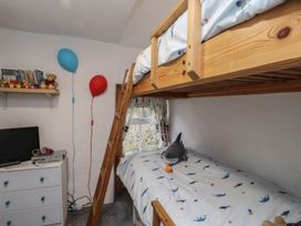 A bedroom with a bunk bed and a television at Dolfor in Nefyn