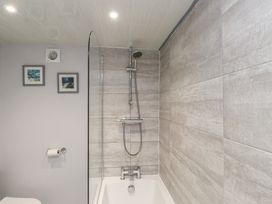 A bathroom with a bathtub and shower fittings at Dolfor in Nefyn