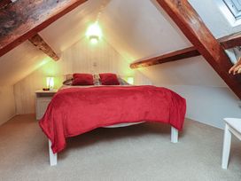 A bedroom with a bed and nightstand at Dolfor in Nefyn