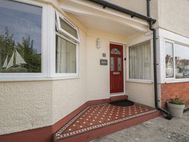 An entrance with a red door and windows at Roma in Rhos-on-Sea