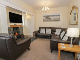 A living room with a sofa and armchairs at Roma in Rhos-on-Sea