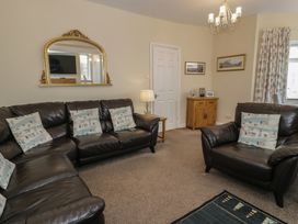 A living room with a sofa and armchair at Roma in Rhos-on-Sea