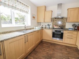 A kitchen with wooden cabinets and modern appliances at Roma in Rhos-on-Sea