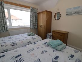 A bedroom with two beds and a wardrobe at Roma in Rhos-on-Sea