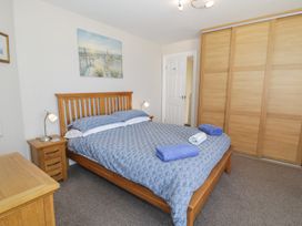 A bedroom with a bed and bedside lamp at Roma in Rhos-on-Sea