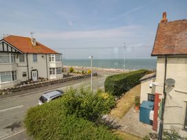 A view of a seaside road with houses and the sea at Roma in Rhos-on-Sea