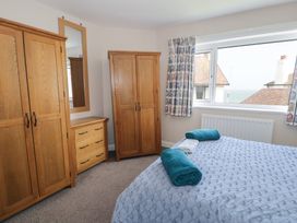 A bedroom with a bed and wooden furniture at Roma in Rhos-on-Sea