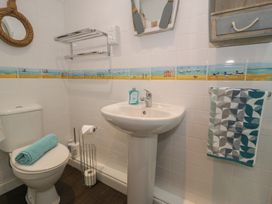 A bathroom with a toilet, sink, and decorative elements at Roma in Rhos-on-Sea