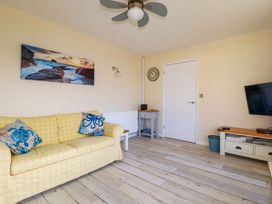 A living room with a sofa and television at Merlin's Retreat in Tintagel