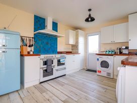 A kitchen with appliances and cabinets at Merlin's Retreat in Tintagel
