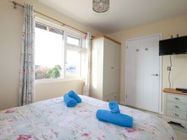 A bedroom with a bed and towels on top at Merlin's Retreat in Tintagel